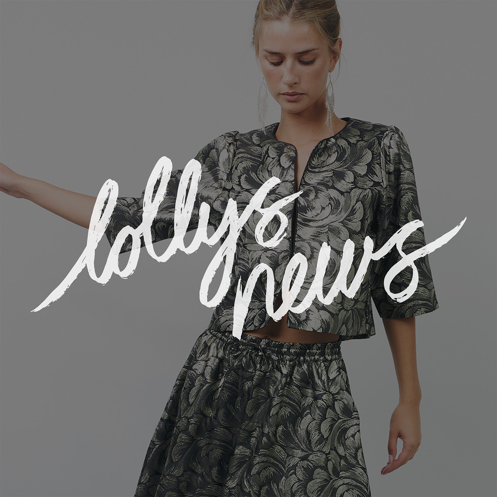 Woman wearing a dark jacquard set with a golden leaf pattern, standing against a light background. The text lollys news appears across the image.