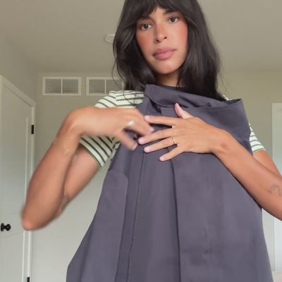 Video of a woman showcasing the BulgariaLL jacket from Lollys Laundry in a muted purple shade, featuring an oversized fit, buttons and wide sleeves, styled with a striped top and jeans.